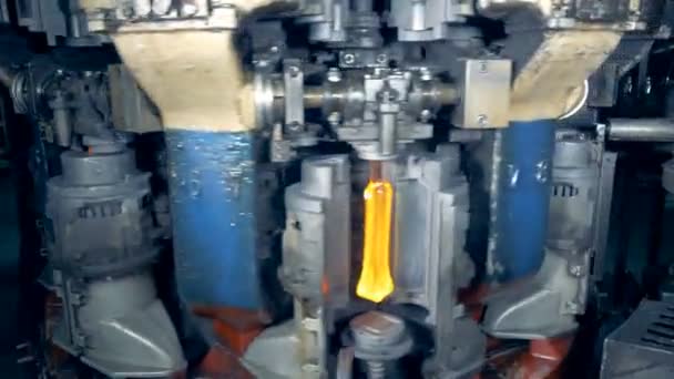 Máquina de fábrica giratoria masiva de la que emergen botellas de vidrio — Vídeo de stock