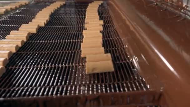 Close-up beeld aan het proces van gieten snoepjes met chocolade. — Stockvideo