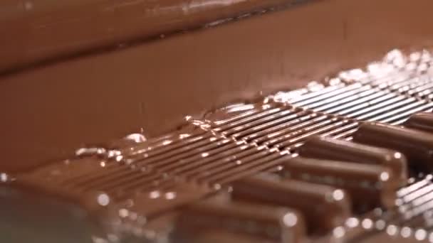 Schokoriegel werden mit flüssiger Schokolade übergossen. Nahaufnahme. — Stockvideo