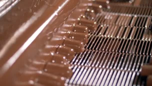 Nahaufnahme des Prozesses von gegossenen Schokoriegeln mit flüssiger Schokolade. — Stockvideo