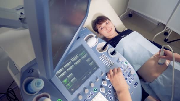 Draufsicht einer jungen Schwangeren, die sich einer Ultraschalluntersuchung unterzieht — Stockvideo