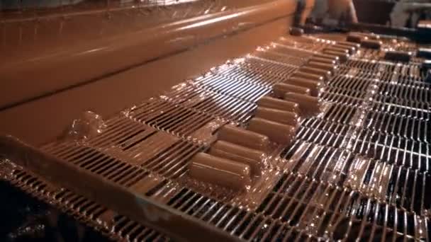 Godis är hällde med choklad på produktionslinjen på en godisfabrik. — Stockvideo