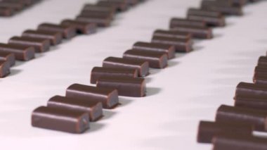 Hazır yapılmış çikolata tatlılar şeker fabrikası'nda üretim hattı boyunca hareket ediyor.