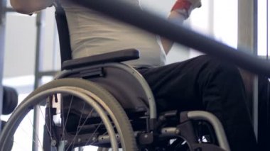 Eğitim salonunda çabaları güçlü iradeli atlet tekerlekli sandalyede yapar.