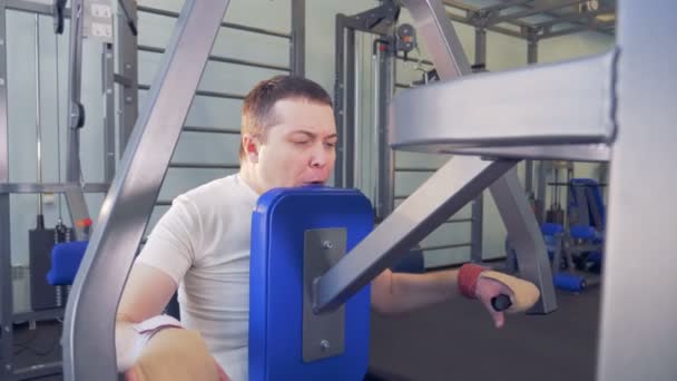 Homme en fauteuil roulant se surmonte en faisant des exercices dans la salle de gym . — Video