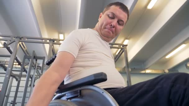 Homem com deficiência olha para a mão segurando halteres durante o exercício . — Vídeo de Stock
