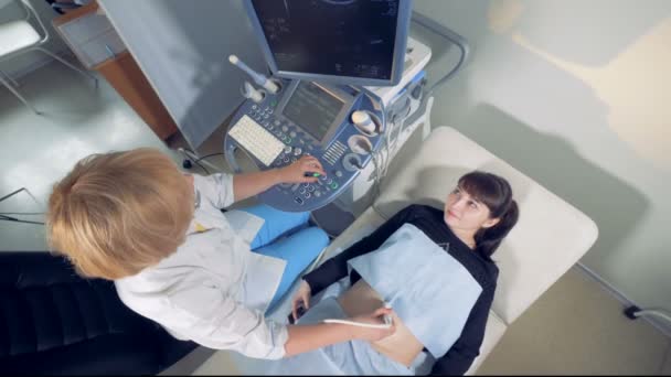 Vista dall'alto di una donna incinta che sta attraversando una sessione di sonografia con una ginecologa donna — Video Stock