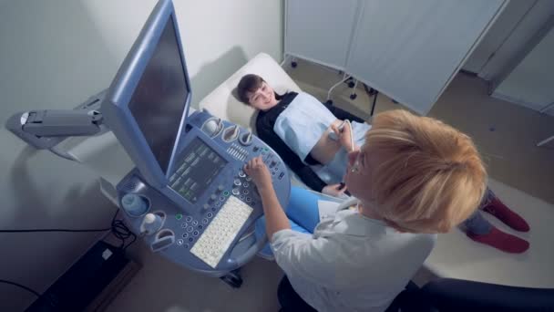 Echografie proces van een gelukkig zwangere vrouw gecontroleerd door een verloskundige — Stockvideo