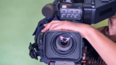 Kameraman bir video kamera Yönlendirme ve onun dış mercek döndürme