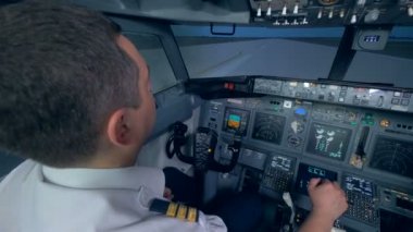 Bir uçak podyumda, iki Pilot uçuş simülatörü kokpit içinde gider..