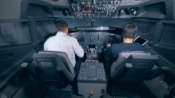 Twee piloten zitten in de cockpit. — Stockvideo