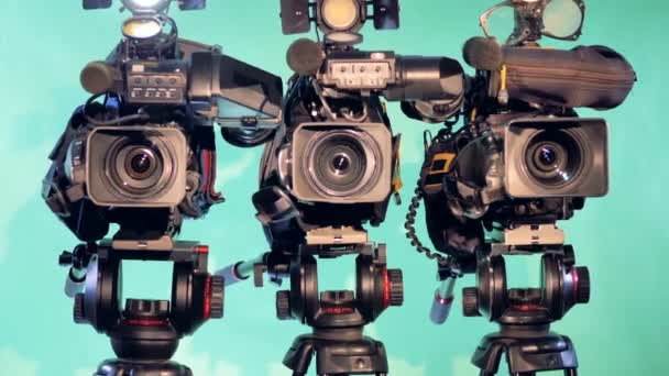 Three video cameras are standing in a studio — Stock Video