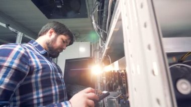 Erkek madenci klavyede yazarak ve bitcoin araştırma işlemi yönetme