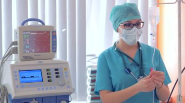 Kadın doktor bir damla şişesi kadar kablolama ve bir monitörde parametrelerini ayarlama