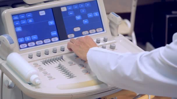Un panel de ultrasonido está siendo regulado por una mano de los médicos — Vídeo de stock