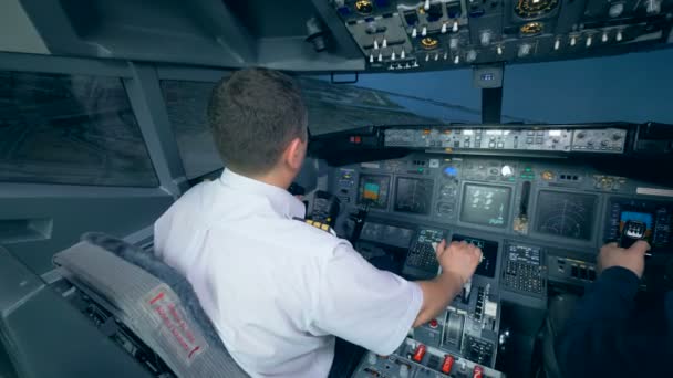 Dos aviadores en simulador de vuelo, sosteniendo timones en una cabina. 4K . — Vídeos de Stock