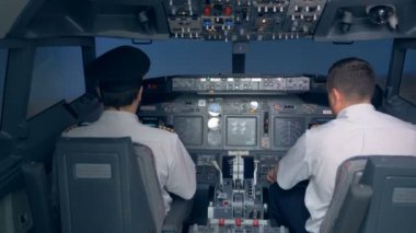 Pilotlar Kokpitte bir uçuş sırasında oturmak..