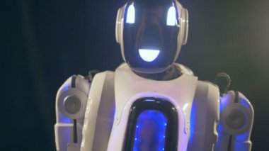 Beyaz robot arkasını dönüyor ve yaprakları.