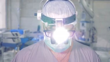 Başını yukarı kaldırarak ve dikkatle kameraya bakarak profesyonel doktor