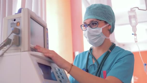 Proceso de trabajo de una doctora durante el cual establece parámetros en un monitor — Vídeos de Stock