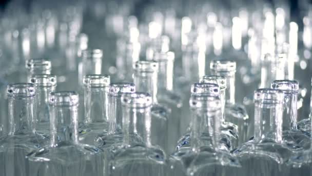 Πολλά γυάλινα μπουκάλια σε ένα μεταφορέα σε ένα εργοστάσιο. 4k. — Αρχείο Βίντεο