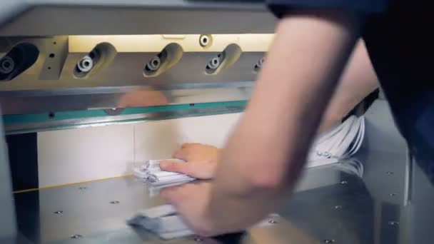 Різак зсуває додаткові ребра паперових листів, після чого чоловік все відсуває — стокове відео