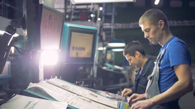 İki mühendis dokunmatik ekran kullanarak endüstriyel bilgisayarlı ekipman ile çalışıyor.