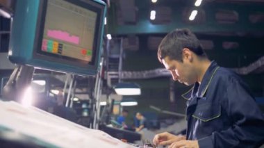 Bir yazdırma fabrika tipografi bilgisayarla çalışan adam.