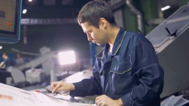 Fabrika hattı inductrial tesisi ile bilgisayarlı makine çalışma ile çalışan adam.