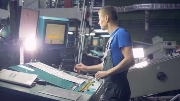 Arbeiter an einer computergesteuerten Industriemaschine, die mit Fabrikband arbeitet. — Stockvideo