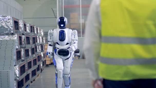 Um robô vai em direção a um homem e dá-lhe um oi-cinco . — Vídeo de Stock