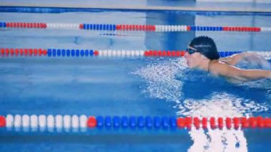 Bir kadın, tek başına bir havuzda yüzüyor.