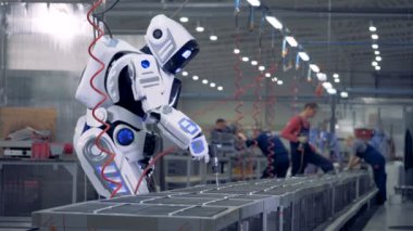 İnsan robot gibi özel bir araç kullanarak bir fabrikada çalışıyor.