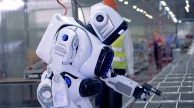 Fabrika işçisi denetler droidler işe, yakın çekim.