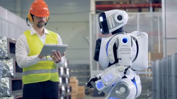 Fabriken-anställd kommunicerar med en humanoid i gester — Stockvideo