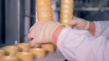 Bir yığın gözleme bardak Konveyör bant bir fabrika işçisi tarafından eklenen
