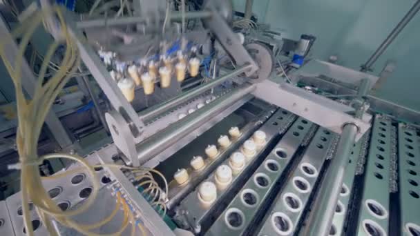 Mecanismo de fábrica está realocando copos de waffle de sorvete dentro de uma pista de metal — Vídeo de Stock