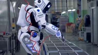 İnsan benzeri robot bir fabrika biriminde bir matkap ile çalışma