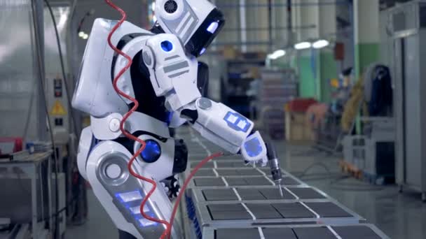 Ανθρωποειδές ρομπότ λειτουργεί με ένα τρυπάνι σε μια εργοστασιακή μονάδα — Αρχείο Βίντεο