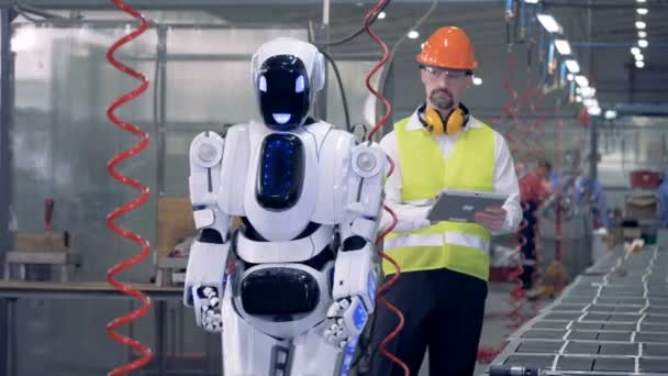 Drilling process performed by a cyborg is being controlled by a factory employee — Stock Video