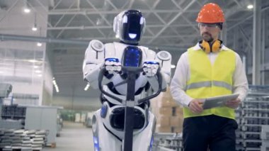 Cyborg bir erkek işçi tarafından düzenlenmiş iken bir taşıma aracı fabrika birim boyunca hareket ediyor