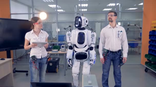 Робот повторяет движения инженера-мужчины под контролем женщины. — стоковое видео