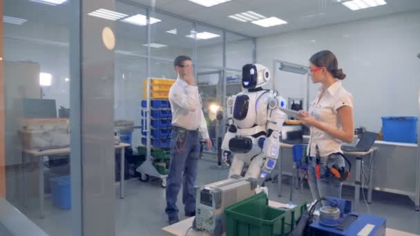 Μια ομάδα μηχανικών που κατευθύνει ρομπότ κινείται με χειρονομίες και υπολογιστή — Αρχείο Βίντεο