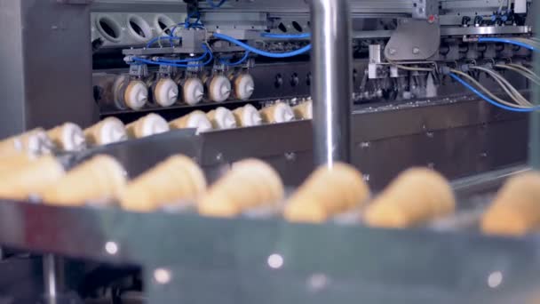 Blokken van ijs in wafer cups zijn krijgen die op de transportband metalen tangen — Stockvideo