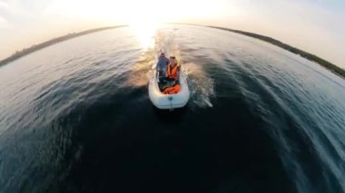 Front view of a motorboat with two men and lifevests