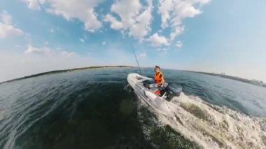 A man in a lifevest is driving an inflatable boat