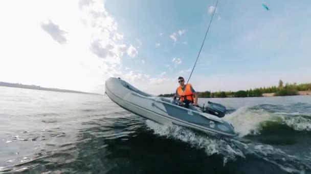 Boční pohled na gumový člun s mužem plující podél řeky — Stock video