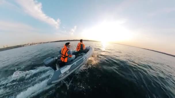 Side view of a motorboat being driven by the men in lifevests — Stock Video