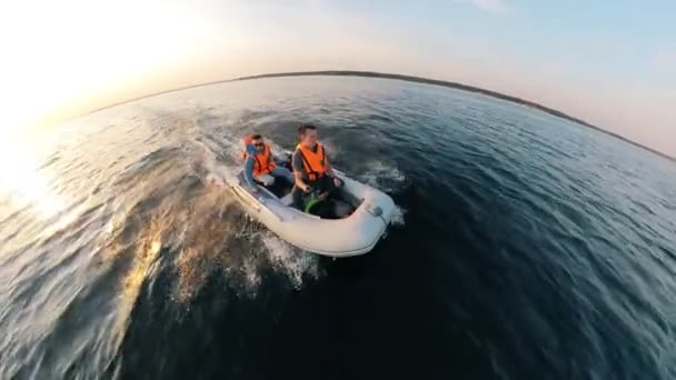 Bateau en caoutchouc navigue le long de la rivière avec deux hommes dedans — Video