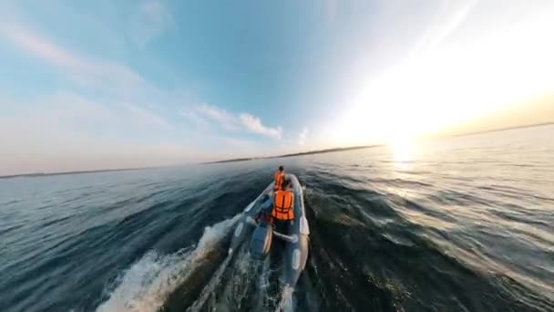 Двое мужчин едут на надувной лодке вдоль озера — стоковое видео